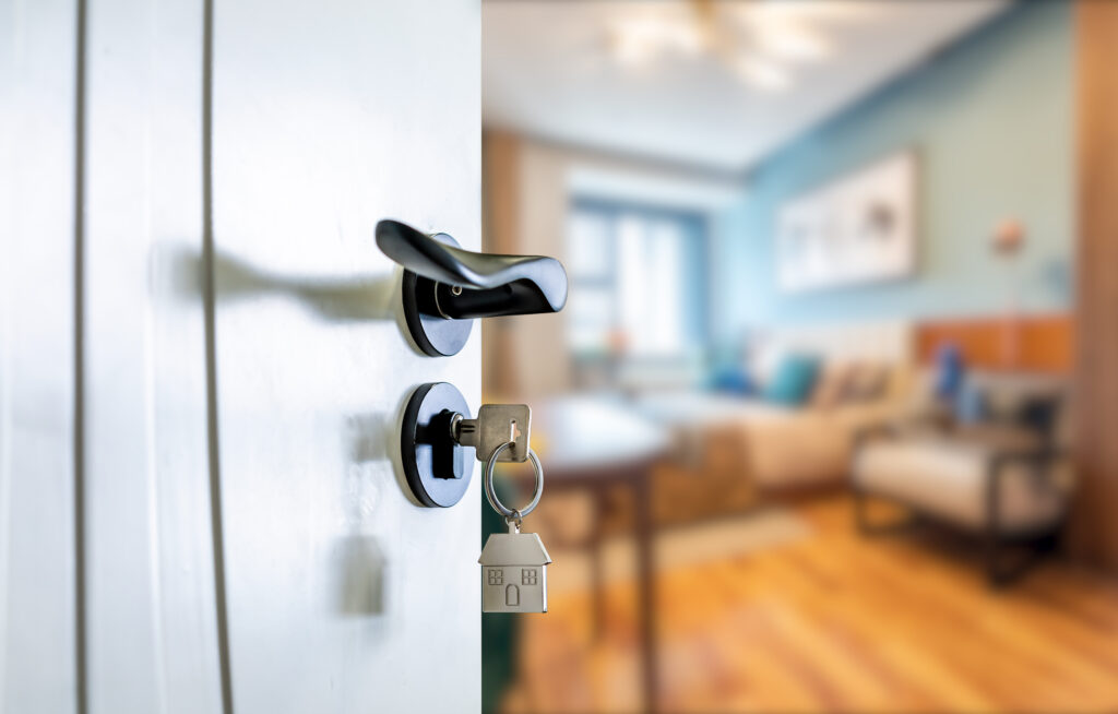 Open door with keys, key in keyhole Paul Chapman Realtor will help you find your dream home.